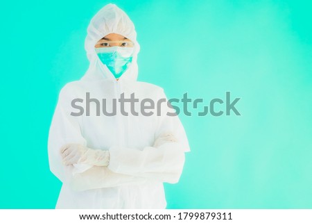 Portrait beautiful young asian doctor woman wear ppe or  personal protective equipment for protect from coronavirus or covid19 with empty card white board on blue isolated background