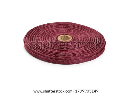 red stripe round bobbin cotton tape. strong braided webbing for making belts, on a white background.