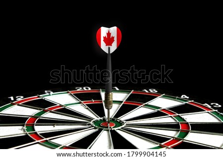 The flag of Canada is featured on the dart board game, the concept of achieving goals.
