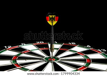 The flag of Germany is featured on the dart board game, the concept of achieving goals.