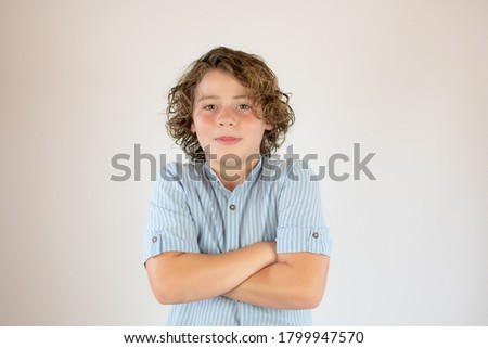 Boy with blue shirt with arms crossed