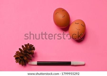 The eggs painted with smile emoticon isolated on pink background