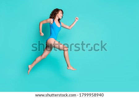Profile photo of adorable pretty motivated young lady model jump trampoline pool ocean party play enjoy advert competition marathon dressed blue swimsuit isolated teal color background