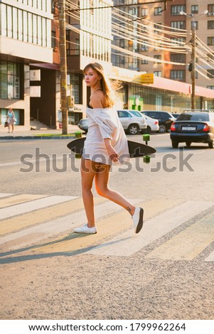 Young woman with skateboard in hands