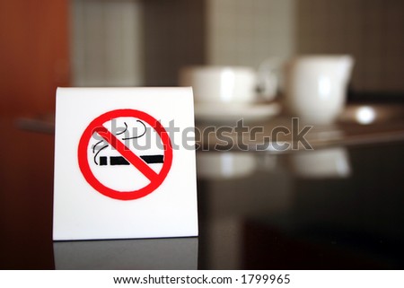 A white no smoking sign displayed on a table in a cafe