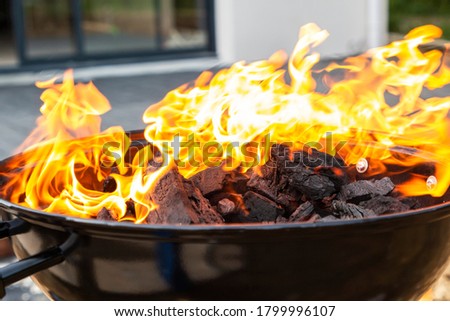 black barbecue with burning coals outside, fire