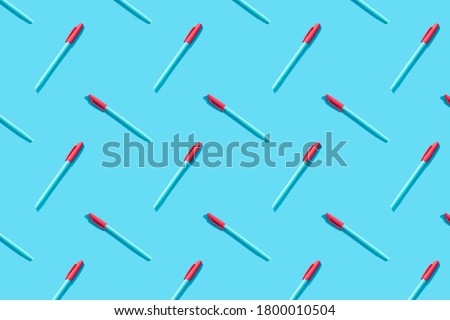 Blue pens with red caps lie on a blue background. The concept of training, business, school, office. Minimalism, copy space, pattern. Royalty-Free Stock Photo #1800010504