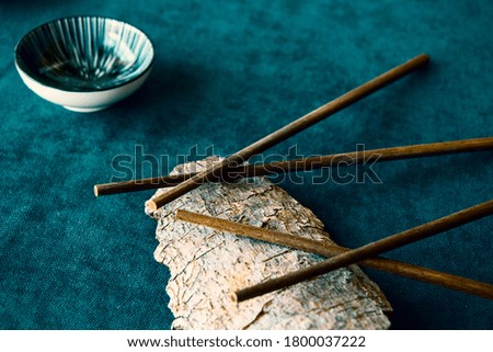 Empty Asian dishware, bowl, pate and chopsticks on the blue background, restaurant tableware