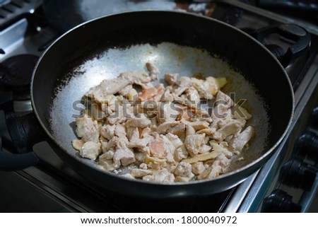 chicken pieces frying without oil in the cooking pan stock photos                      