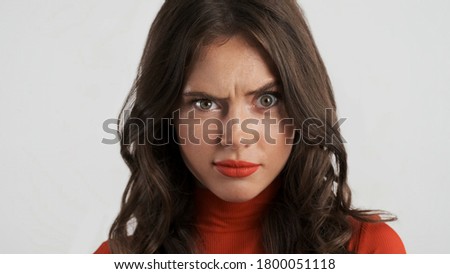 Portrait of attractive brunette girl weirdly looking in camera over white background