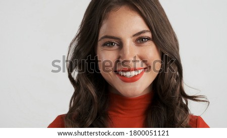 Portrait of beautiful smiling brunette girl happily looking in camera over white background  