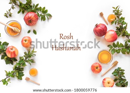 Rosh Hashanah jewish New Year holiday concept. Creative layout of traditional symbols - apples, honey, pomegranate isolated on white, top view, copy space. Royalty-Free Stock Photo #1800059776