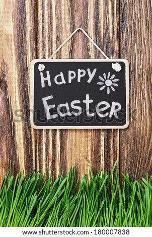 blackboard with wishes for a happy Easter hanging on the fence