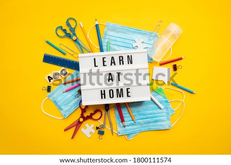 Learn at home lightbox message with school equipment and covid masks