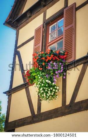 An image of flowers at a half-timbered house window