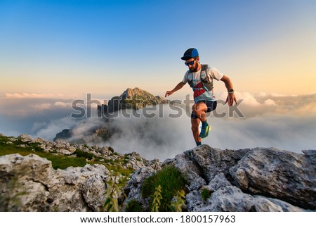 Man ultramarathon runner in the mountains he trains at sunset Royalty-Free Stock Photo #1800157963