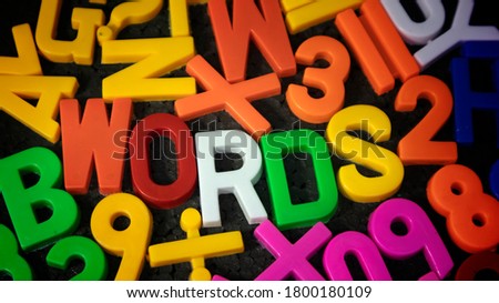 Words in random multi color alphabet on black background, language education concept,  