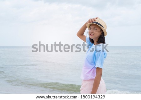 Asian young girl having fun at the beautiful sea.