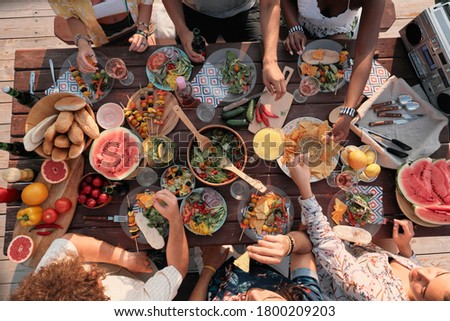 High angle view of group of people sitting at the table and have dinner they celebrating the holiday outdoors