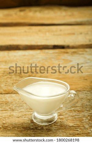 cream in a jug on a wooden table.