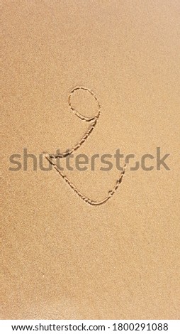 handwriting font number TWO on nature sand at the seaside beach
