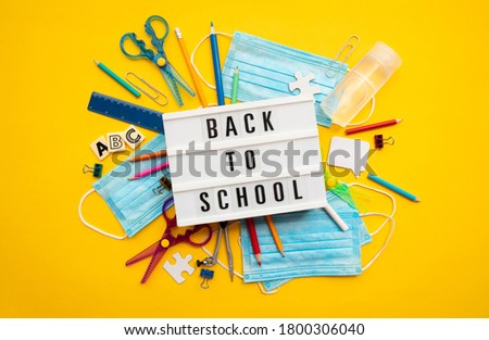 Back to school lightbox message with school equipment and covid masks
