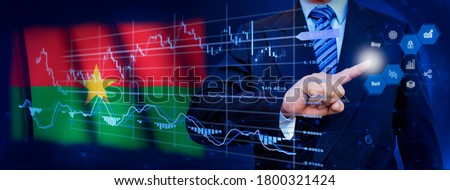 Businessman touching data analytics process system with KPI financial charts, dashboard of stock and marketing on virtual interface. With Burkina Faso flag in background.