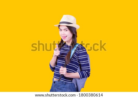 Asian woman tourist was running her to various places.happy excited emotional young woman photographer tourist standing isolated over yellow background