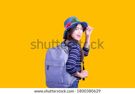 Asian woman tourist was running her to various places.happy excited emotional young woman photographer tourist standing isolated over yellow background