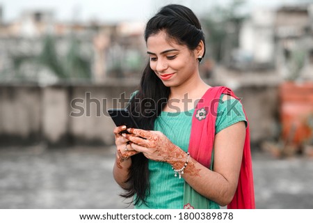 Pretty young Indian woman using her phone.