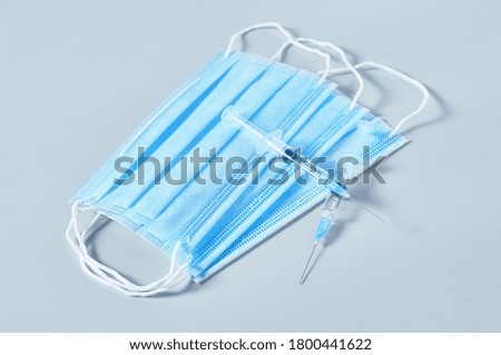 Surgical masks for cover mouth and nose and syringes on gray background. Concept of protection, epidemic or pandemic, corona virus, covid-19