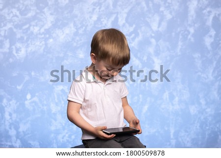 a three-year-old child sits with a smartphone in his hands and watches cartoons or plays. the concept of the prohibition of computer games and the negative impact on the psyche of children.