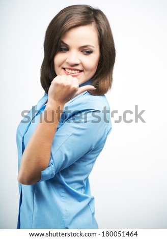 Attractive young woman in a blue blouse. Indicates her finger back. On a gray background