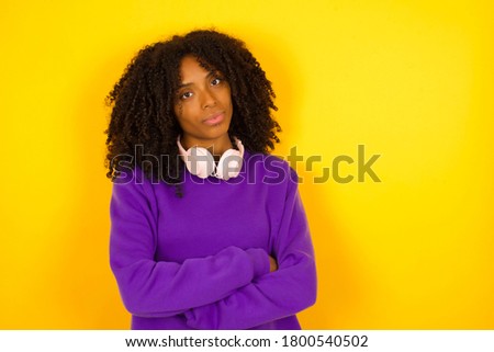 Waist up shot of beautiful self confident cheerful young African American woman entrepreneur has broad smile, crosses arms, happy to meet with colleague, dressed in fashionable clothes.