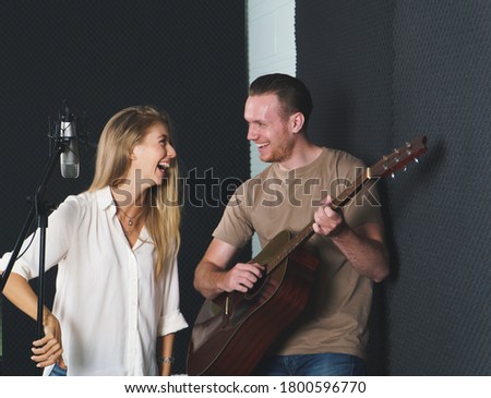 woman singer And man guitarist Caucasian people are practicing and Have fun laughing together in the sound recording studio. concept Artist audition for media, music, and performance producer.