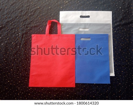Non Woven Colorful Fabric Shopping Bags on Black Background. Flat Lay. Copy Space for Text and Logo for Your Advertisements. Handle Loop Bags, D-cut ECO Bags