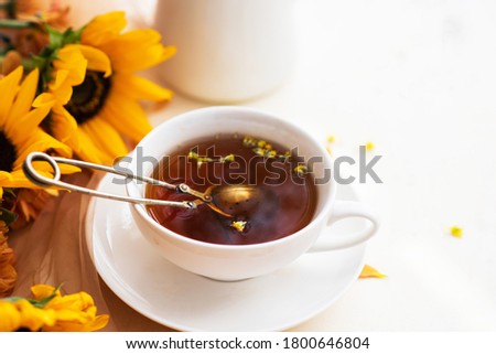 Autumn, fall leaves, flowers hot cup of herbal tea on wooden rustic background. Seasonal, morning tea. Sunday relaxing and still life concept. Toned image.