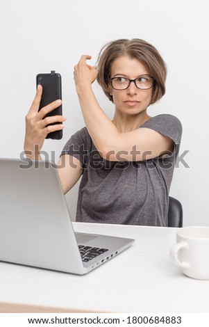 A woman blogger holds a smartphone in her hand and prepares for an online conference.