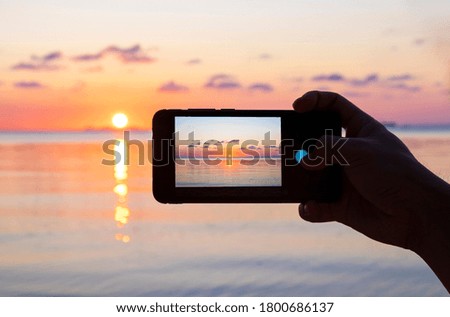 picture of sunset over the sea on the cellphone