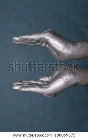 close-up of human hands represent a form of bowls or flower on blue-gray background, side view