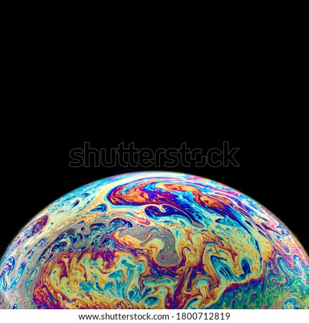 The colorful and beautiful patterns of soap bubbles are on the bottom of the black background. It's a frame,a edge element,a background pattern.