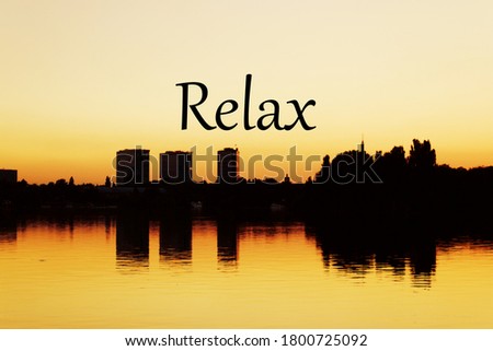 A silhouette shot of a cityscape next to a calm sea with Relax written in the middle