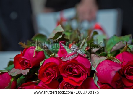 Gold wedding rings on a bouquet of red gold flowers. Rings on the wedding bouquet .