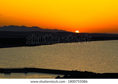 Beautiful sunset with Mountain and sea . The picture was taken from Algeria and what do you see is Morocco, so you can enjoy the sunset adorned with full orange sky