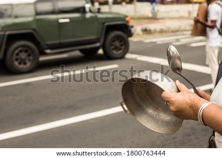 A hand holding a pot and a spoon, making noise in the street at the protest against the corruption in Panama.