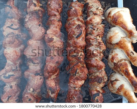 Grilled kebab cooking on metal skewer. Roasted meat cooked at barbecue. BBQ fresh beef meat chop slices. Traditional eastern dish, shish kebab. Grill on charcoal and flame, picnic, street food