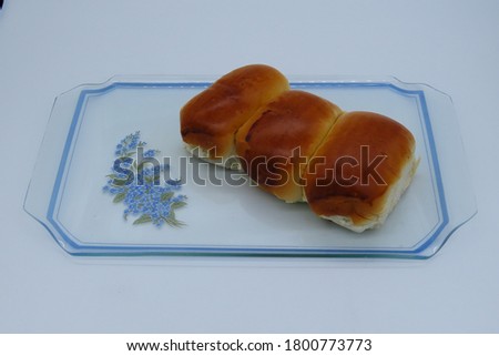 
Three sweet and salty breads in a decorated glass tray. Exclusive bread  from Brazil named "Pão de cará" in portuguese.