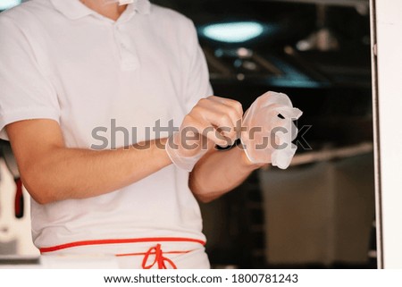 Cook puts on disposable gloves. Pandemic remedies. Covid safety.