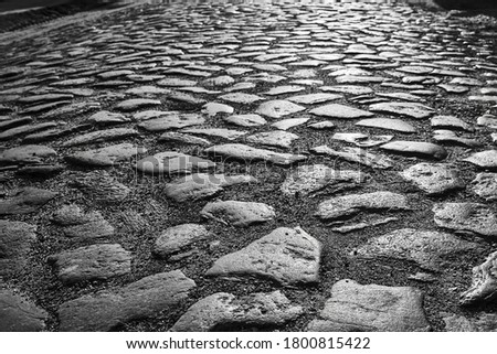Granite cobblestones of a country road in Poland, black and white
