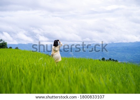 Young woman taking picture of mountain scape.